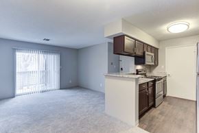 Schaumburg apartment for rent - A kitchen with white cabinets and a window with white blinds.