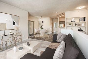 Beavercreek apartment for rent - A modern living room with a white couch and a large abstract painting on the wall.