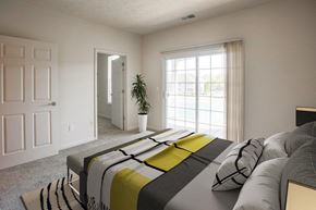 Beavercreek apartment for rent - a bedroom with a bed and a large window