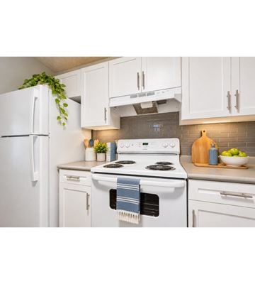 Salisbury apartment for rent - A white kitchen with a stove and a refrigerator.
