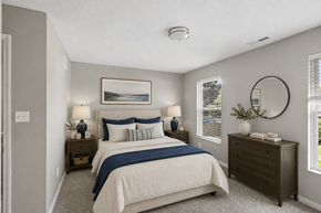 Middletown apartment for rent - A bedroom with a large bed and a round mirror on the wall.