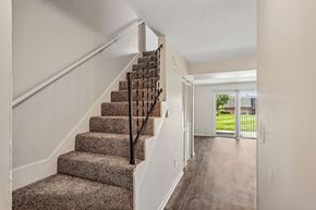 Middletown apartment for rent - A staircase with a carpeted runner and wooden balusters leads to a bright open space.