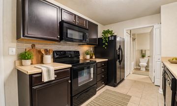 Augusta apartment for rent - A kitchen with black appliances and brown cabinets.