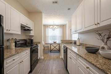 Fayetteville apartment for rent - A kitchen with white cabinets and a black stove top oven.