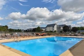 Wyoming apartment for rent - A large swimming pool with a blue tinted water and a cloudy sky in the background.