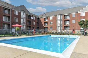 South Bend apartment for rent - A swimming pool in front of a brick apartment building.