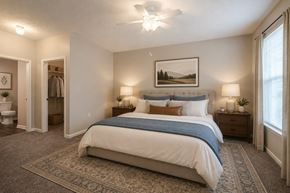 Fayetteville apartment for rent - A bedroom with a large bed and a painting on the wall.
