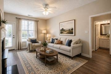 Fayetteville apartment for rent - A living room with a white couch, a coffee table, and a painting on the wall.