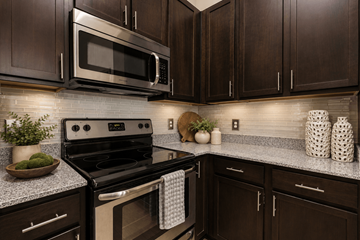 Cornelius apartment for rent - A kitchen with dark brown cabinets and a black stove top oven.
