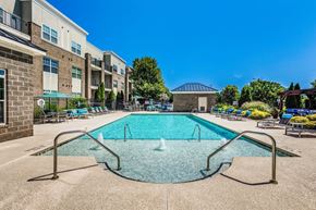 Cornelius apartment for rent - A swimming pool surrounded by a concrete floor and metal railings.