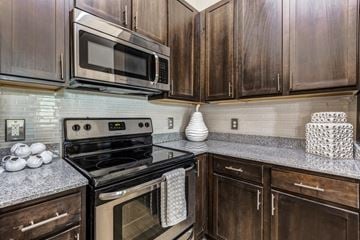 Cornelius apartment for rent - A kitchen with a black stove and wooden cabinets.