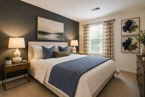 Columbia townhouse for rent - A bedroom with a large bed and a painting on the wall.