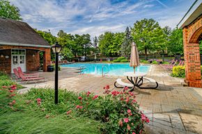 Cincinnati apartment for rent - A pool surrounded by a brick patio and a small building.