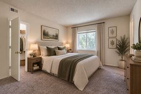 Fayetteville apartment for rent - A bedroom with a large bed and a window with curtains.