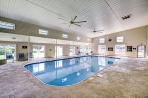 Fayetteville apartment for rent - A large indoor swimming pool with a ceiling fan and multiple windows.