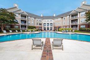 Fayetteville apartment for rent - Two lounge chairs sit on the ground in front of a pool.