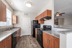 Fayetteville apartment for rent - A kitchen with wooden cabinets and black appliances.