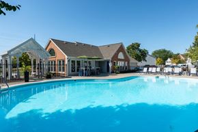 Columbus townhouse for rent - A large swimming pool in front of a building with a poolside lounge.