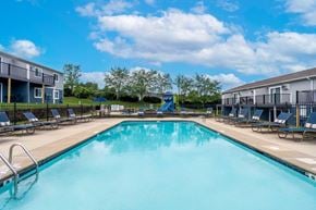 Charlotte apartment for rent - A large swimming pool surrounded by sun loungers and apartment buildings.