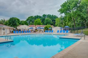 Jeffersonville apartment for rent - a swimming pool with blue chairs around it