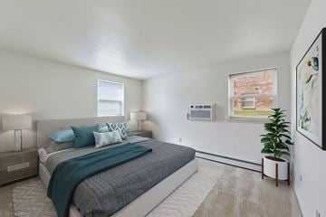 Quakertown apartment for rent - A bedroom with a large bed and a potted plant.
