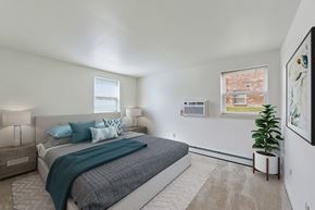 Reading apartment for rent - A bedroom with a large bed and a potted plant.