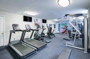 Claymont apartment for rent - a gym with cardio equipment and a tv in a building