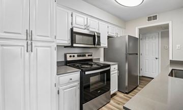 Fort Worth townhouse for rent - A kitchen with white cabinets and stainless steel appliances.