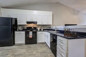 Concord apartment for rent - a kitchen with white cabinets and black appliances