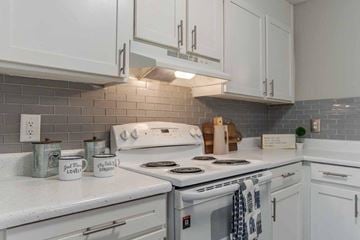 Rock Hill apartment for rent - A kitchen with white cabinets and a white stove top oven.
