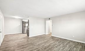 Bethany apartment for rent - A spacious room with a wooden floor and a refrigerator in the corner.