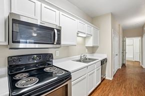 Lancaster townhouse for rent - A kitchen with a black stove top oven and white cabinets.