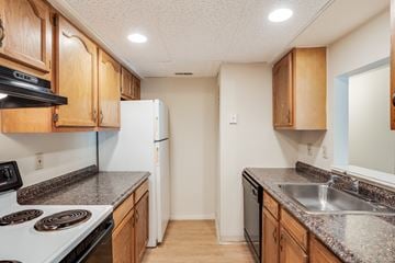 Cincinnati apartment for rent - A kitchen with wooden cabinets and a white refrigerator.