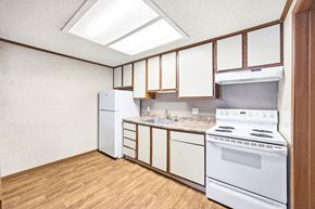 Louisville apartment for rent - A kitchen with white appliances and wooden cabinets.