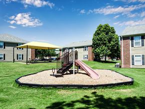 Broken Arrow apartment for rent - A playground with a slide and a yellow umbrella.