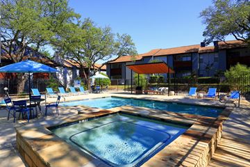Bedford townhouse for rent - A pool with a blue umbrella and chairs around it.