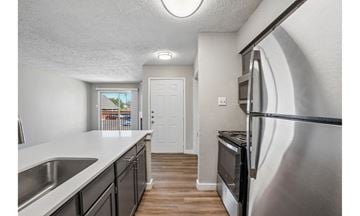 Irving townhouse for rent - A kitchen with a stainless steel refrigerator and a white door.
