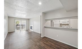 Irving townhouse for rent - A spacious room with wooden floors and a large window.