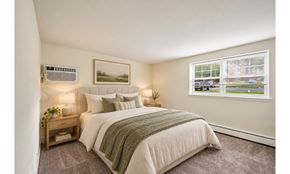 Allentown apartment for rent - A bedroom with a large bed and a window overlooking a street.