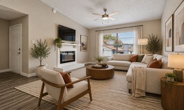 Bedford townhouse for rent - A living room with a white couch, a chair, and a television on the wall.