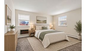 Lansdale apartment for rent - A bedroom with a large bed and a small table with a plant on it.
