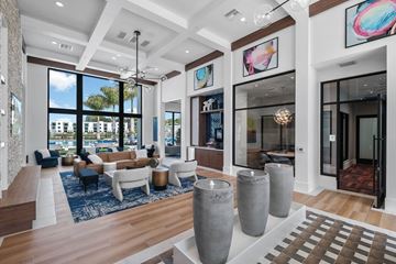 Lake Worth apartment for rent - A spacious living room with a large window, a sofa set, and a rug.