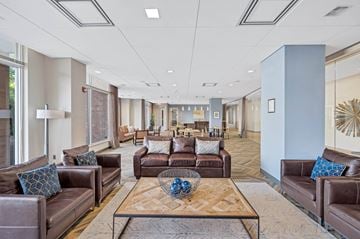 Fairfax apartment for rent - A spacious living room with brown leather couches and a wooden coffee table.