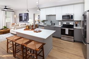 Lake Worth Corridor apartment for rent - A modern kitchen with a white island and wooden bar stools.