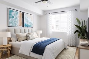 Lake Worth Corridor apartment for rent - A bedroom with a large bed, a ceiling fan, a large window, and a painting on the wall.