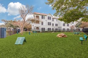 Austin apartment for rent - A large grassy area with benches and a building in the background.