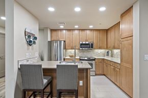 Salt Lake City apartment for rent - a kitchen with wooden cabinets and an island with two chairs