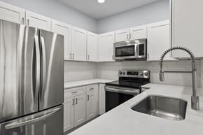 Ogden apartment for rent - A kitchen with a stainless steel refrigerator, microwave, oven, and sink.