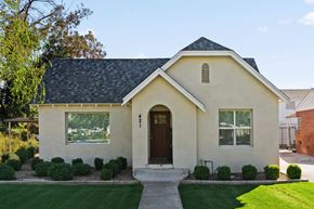Mesa apartment for rent - A small house with a brown door and windows surrounded by greenery.