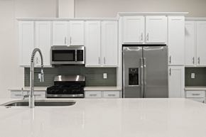 Mesa townhouse for rent - A kitchen with white cabinets and a stainless steel refrigerator.